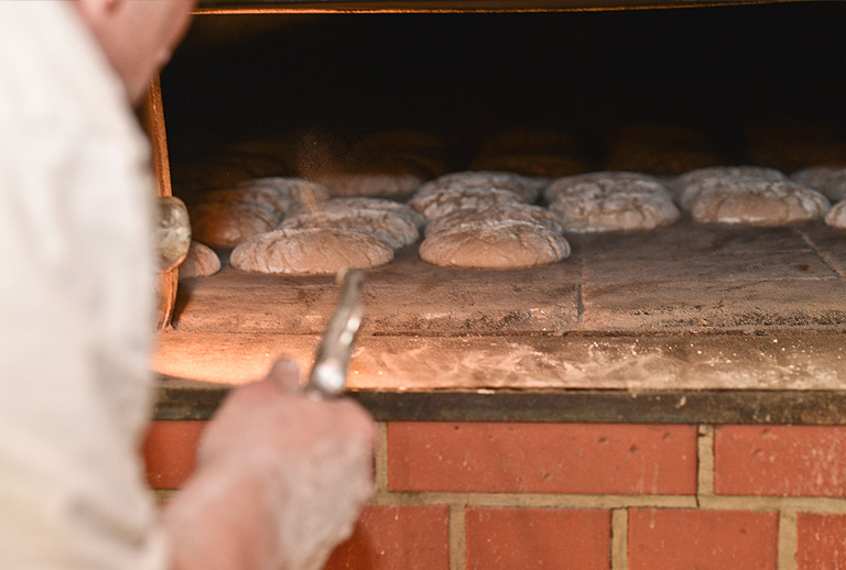 Brote liegen im Ofen – Reichhardt Holzofenbäckerei